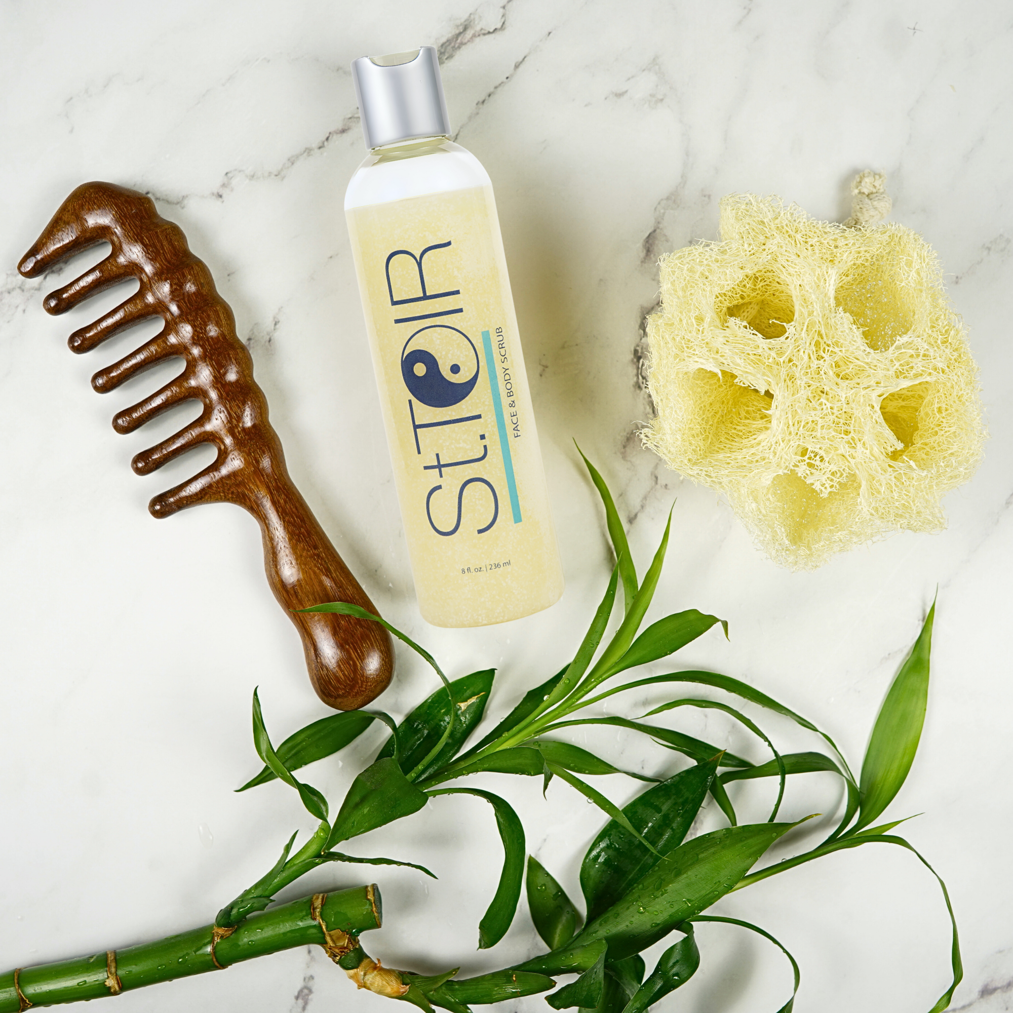 St. Ior hair care product with a wooden comb, sponge, and green leaves on a marble background