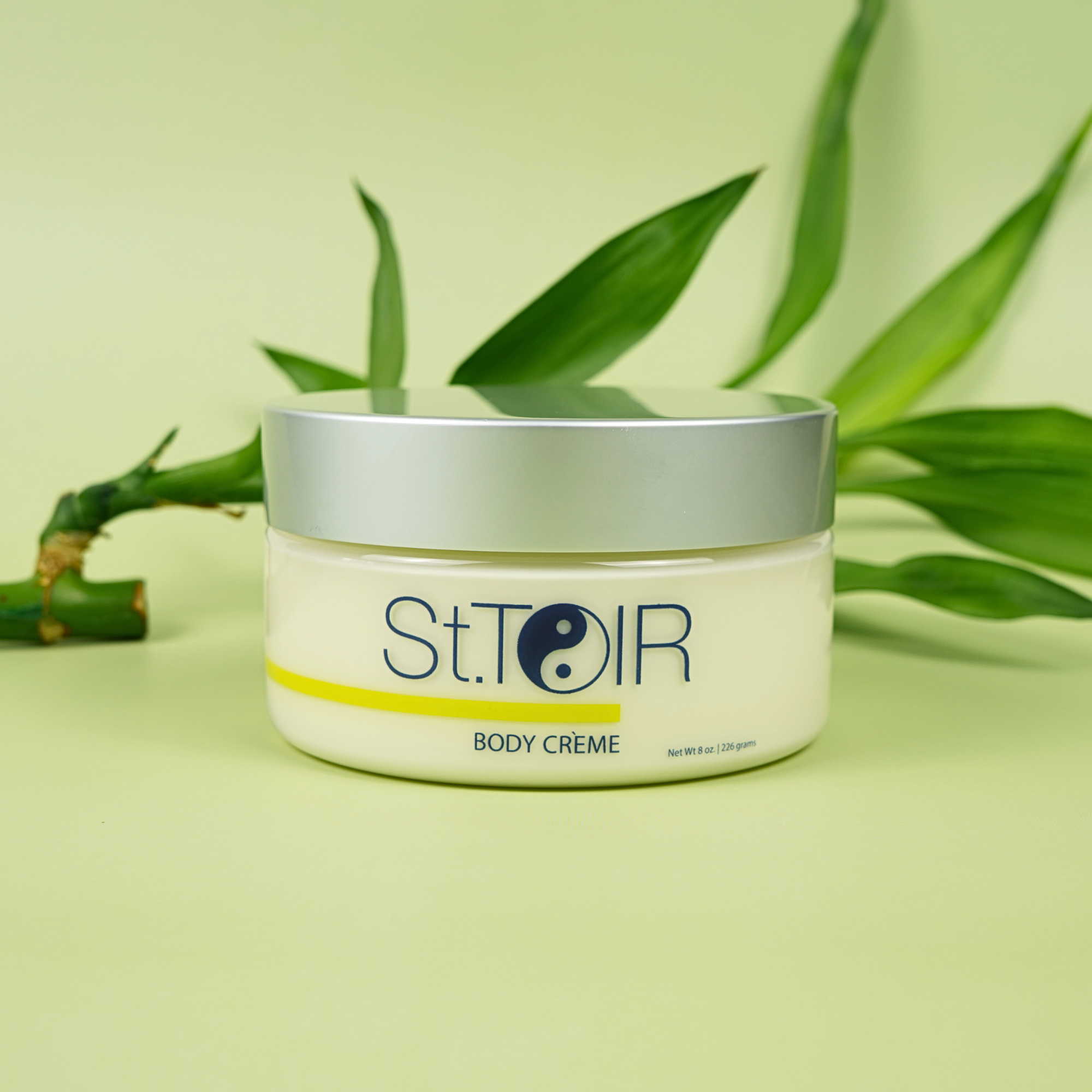 Jar of St. Toir Body Crème with green leaves in the background